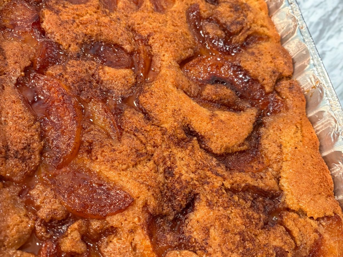Golden fresh-baked peach cobbler in a family-sized pan